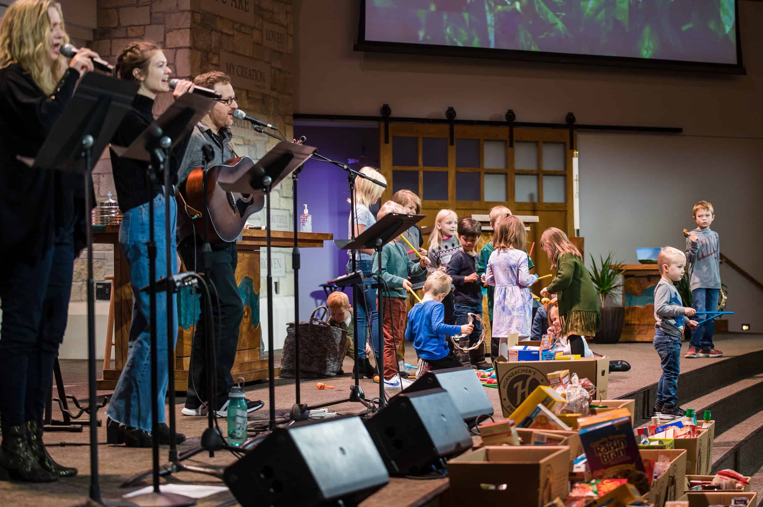 praise singers practicing on stage alongside children